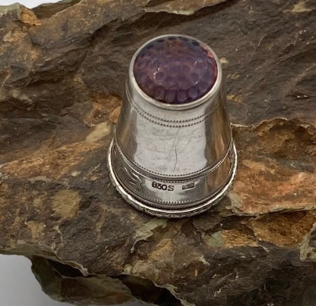 Fingerbøl 830 sølv med lilla topp med skriften Erindring. 